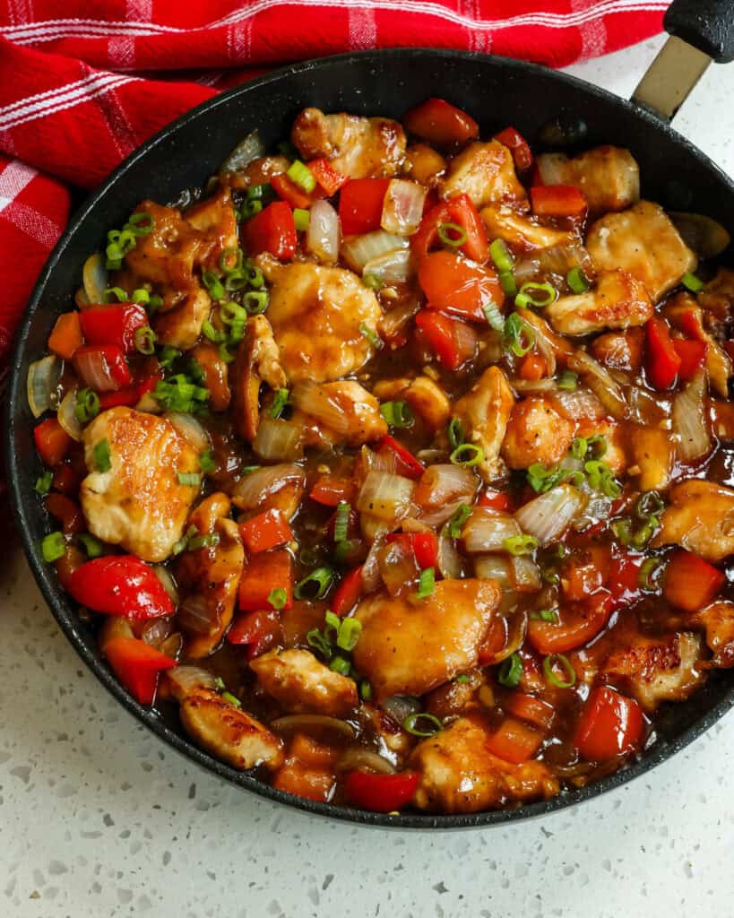 Pepper chicken with green onions, bell peppers, and black pepper sauce. 