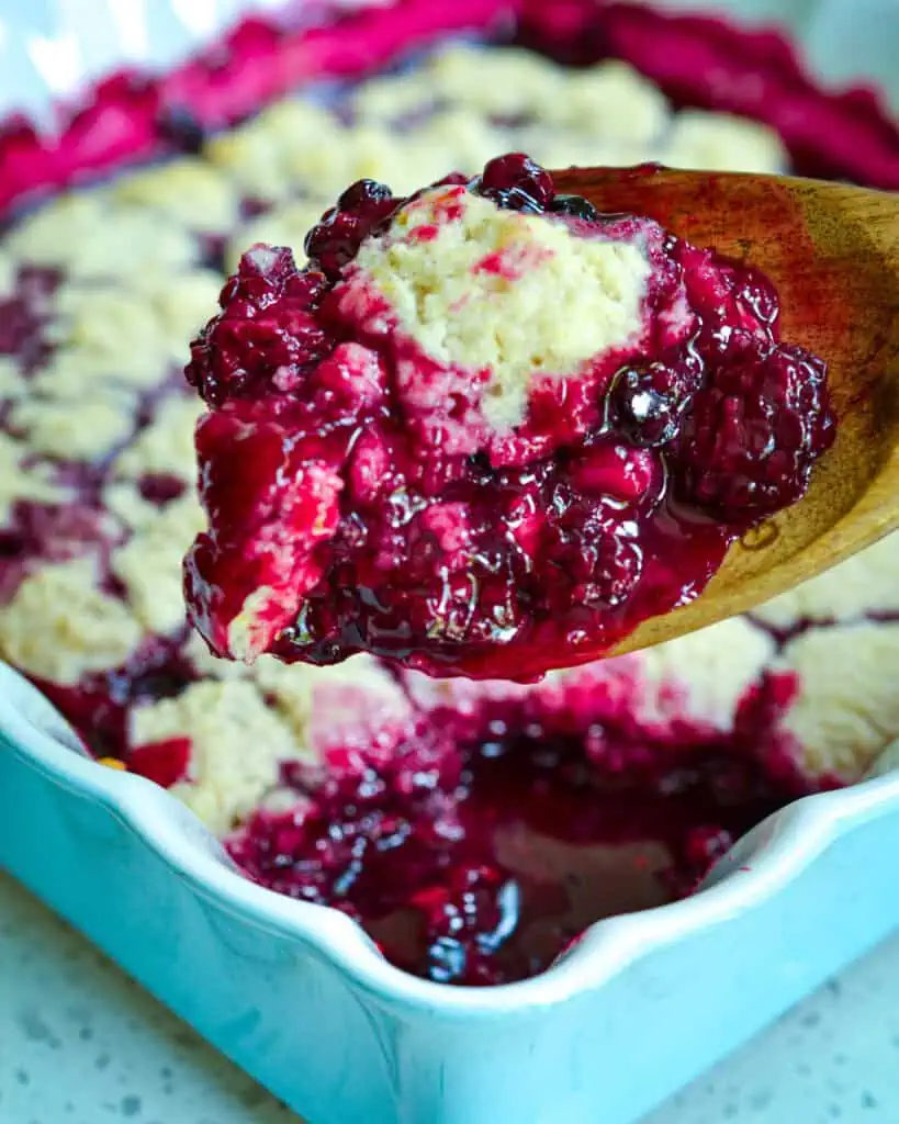 A spoon full of homemade blackberry cobbler. 