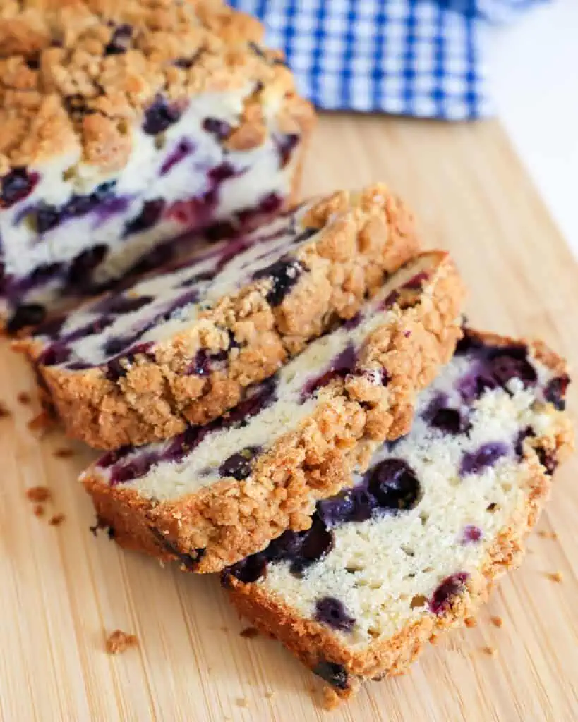Slices of homemade blueberry bread on a cutting board. 