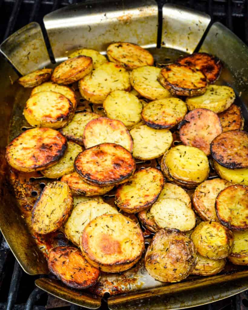 Grilled potatoes with herbs and spices in a grill basket