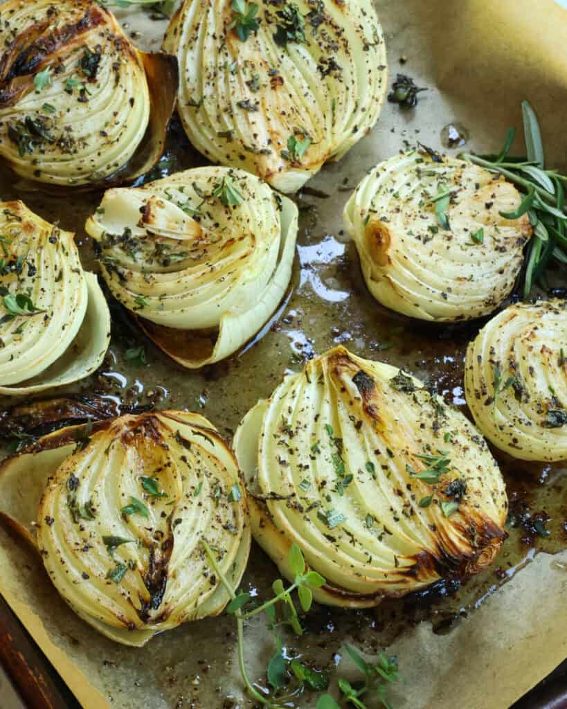 Roasted onions on a baking sheet covered with parchment paper. 