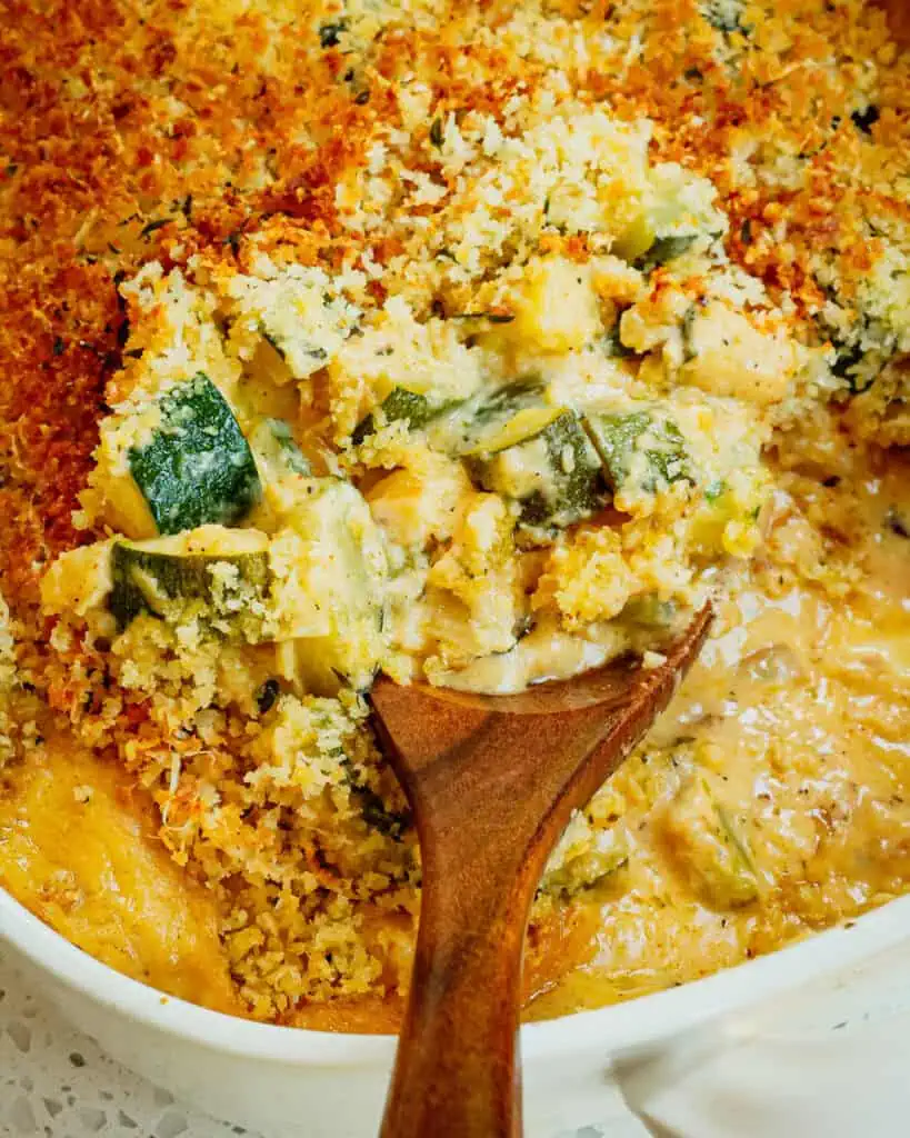 A fresh zucchini casserole with sautéed onions and garlic in a creamy cheese sauce topped with buttery Parmesan Panko breadcrumbs