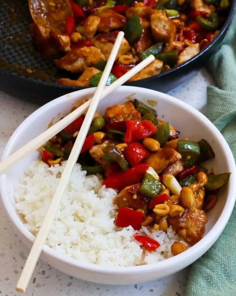 A bowl of kung pao chicken over rice. 
 