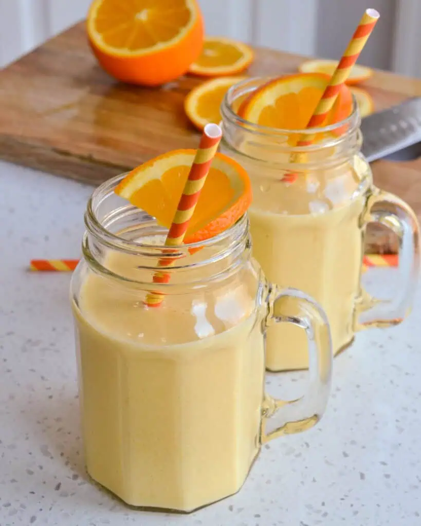 Homemade orange julius in glasses with orange slices and orange straws