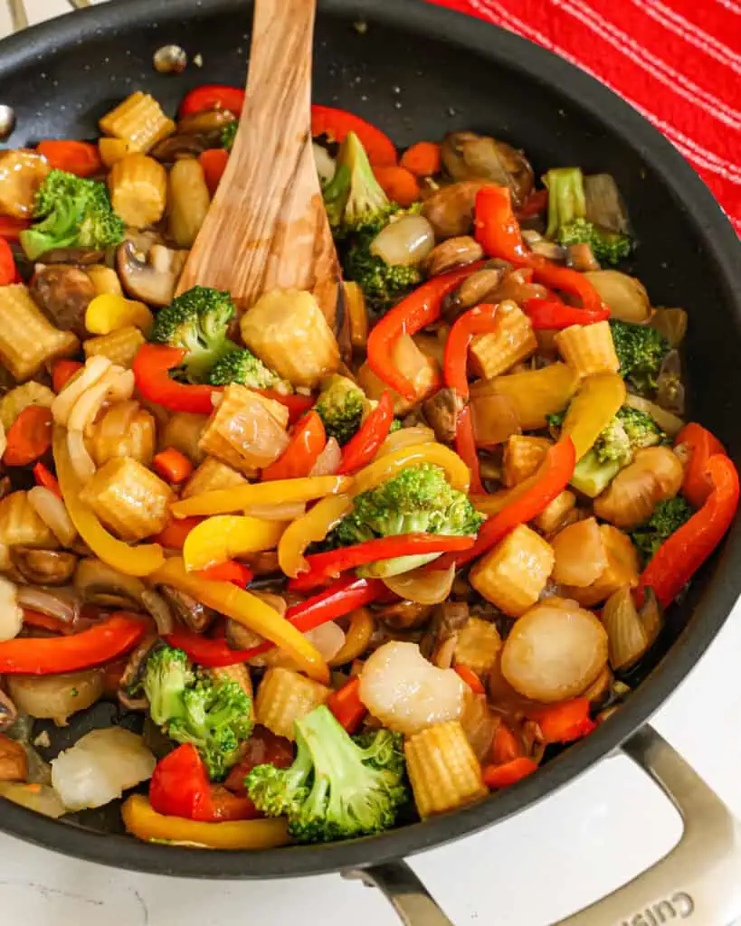 A large skillet full of vegetable stir fry and sauce. 