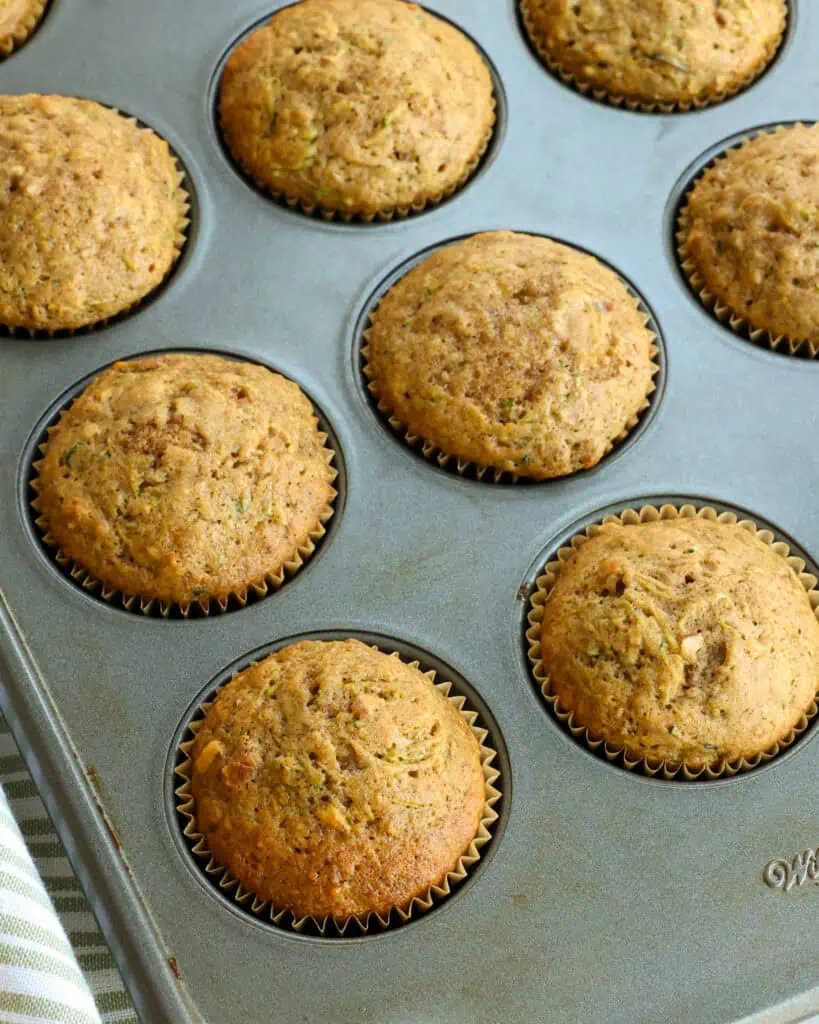 Freshly baked zucchini muffins in a baking wrappers in a muffin tin. 