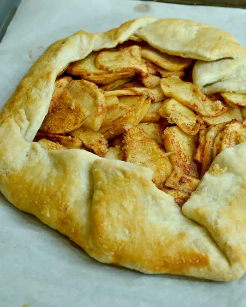 A bsked apple galette on a baking sheet covered with parchment paper, 