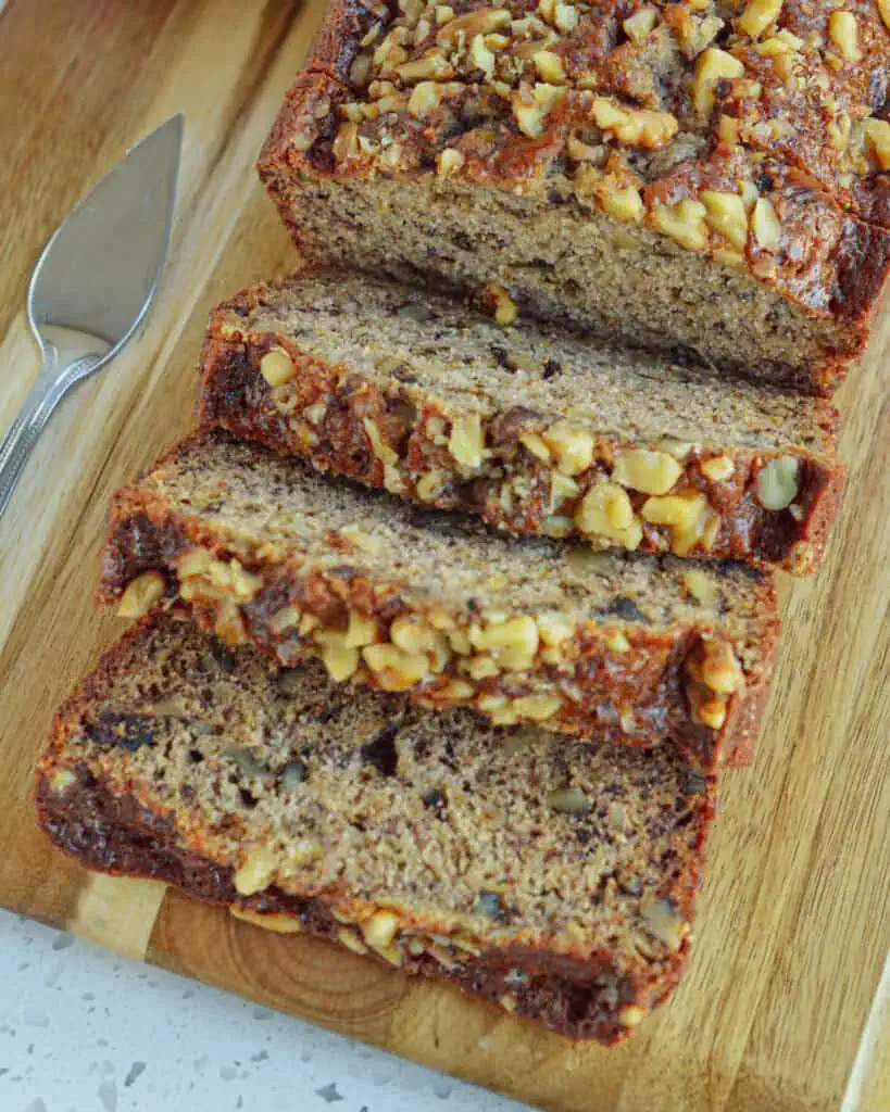 Three slices of banana bread on a cutting board. 