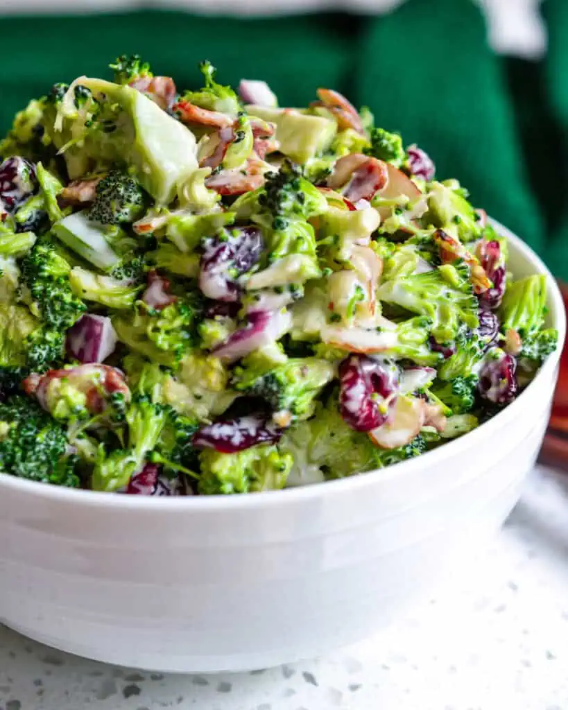 A broccoli salad made with bacon, onions, almonds, dried cranberries and a lightly sweetened easy four ingredient dressing.