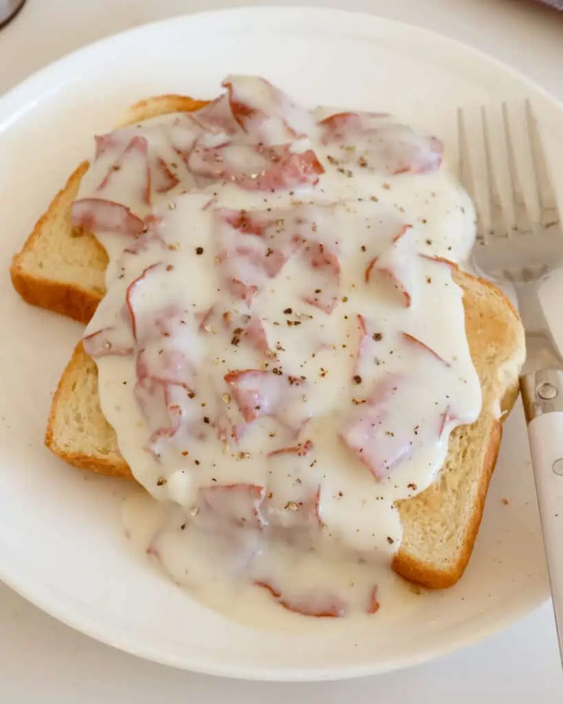 Creamed chipped beef over toast on a single serving plate. 