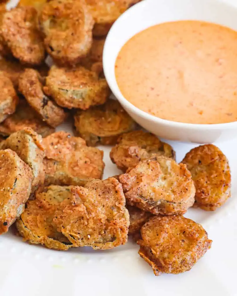 Fried pickles on a plate with comeback sauce. 