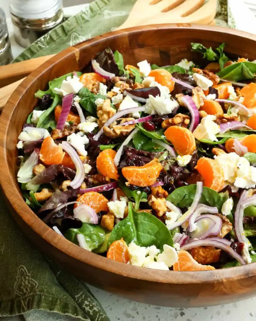 Mandarin orange salad with spring mix, mandarin oranges, toasted walnuts for texture and crunch, dried cranberries, and feta cheese, all tossed with a tangy six-ingredient orange vinaigrette. 