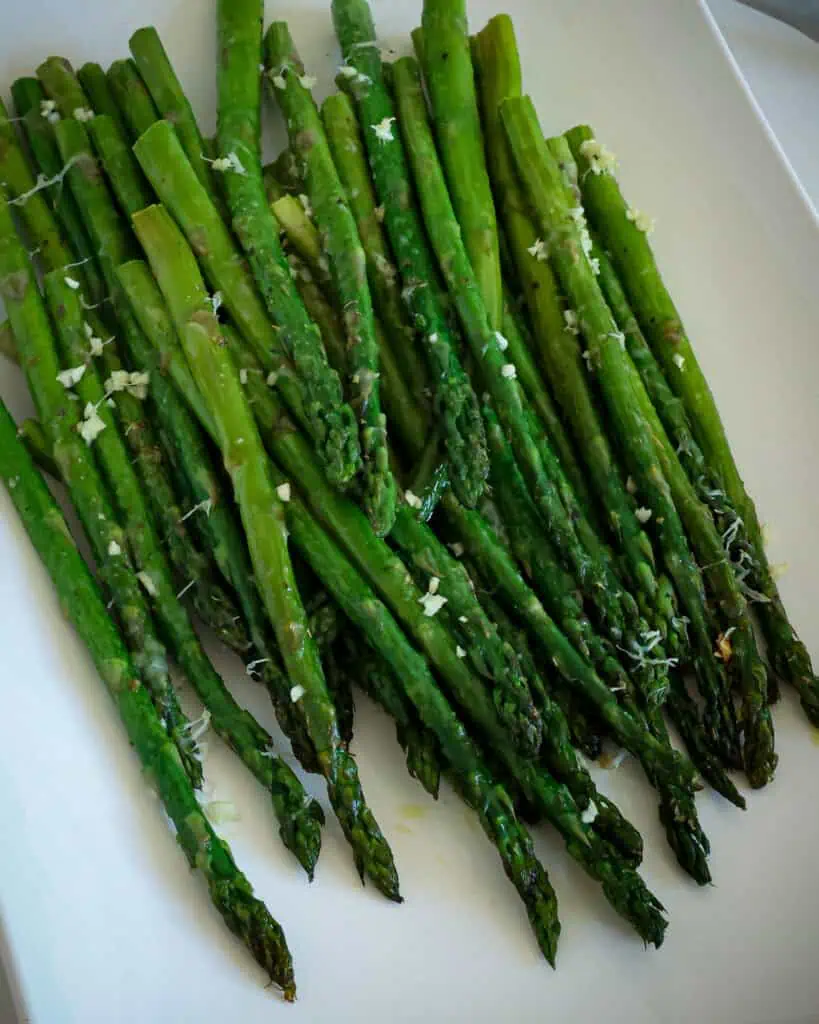 Oven roasted asparagus with garlic and Parmesan cheese on a serving platter. 