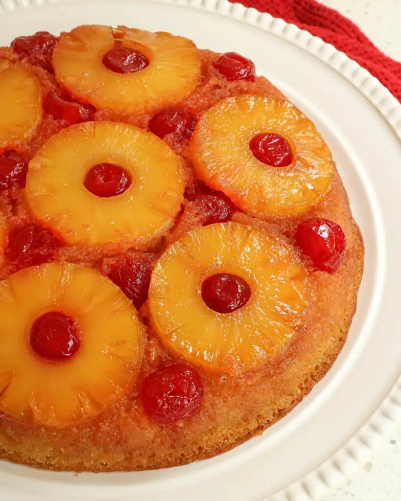 A pineapple upside cake on a large cake stand. 