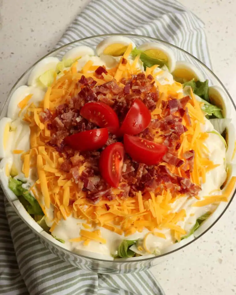 Before serving, sprinkle with shredded cheddar cheese, crisp bacon, and a few more tomatoes. 