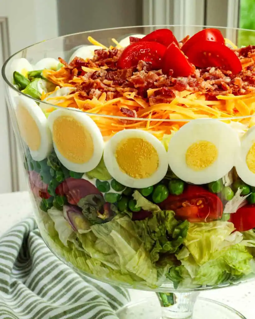 Seven layer salad in a trifle bowl. 