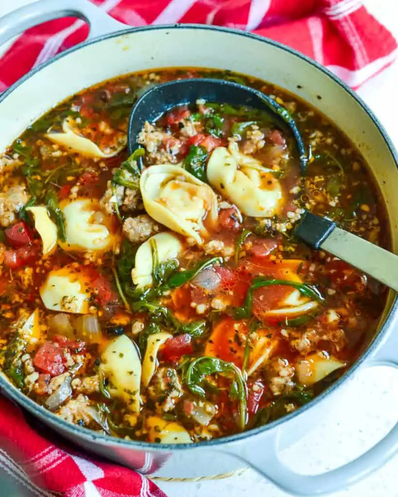 A dutch oven full of sausage and cheese tortellini soup. 
