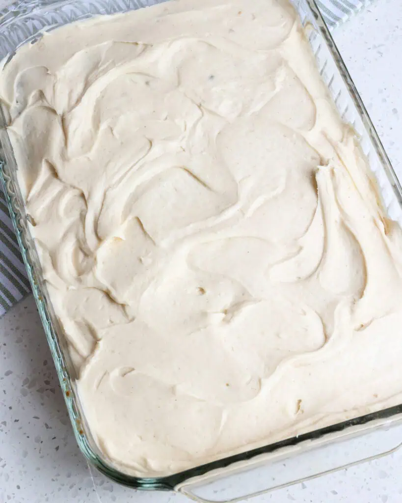 Zucchini cake with cream cheese frosting in a baking dish. 