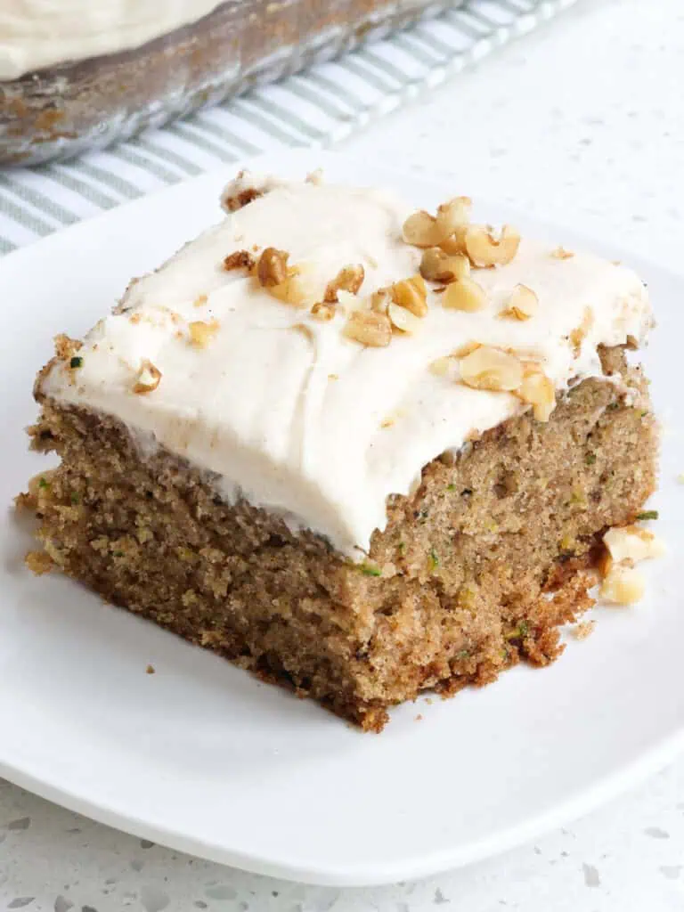 A single piece of zucchini cake on a small square plate. 