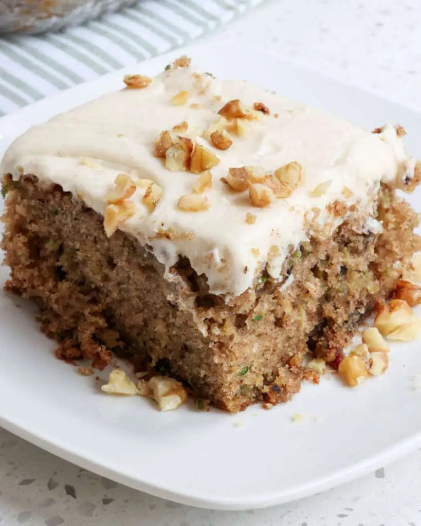 A piece of zucchini cake with cream cheese frosting. 