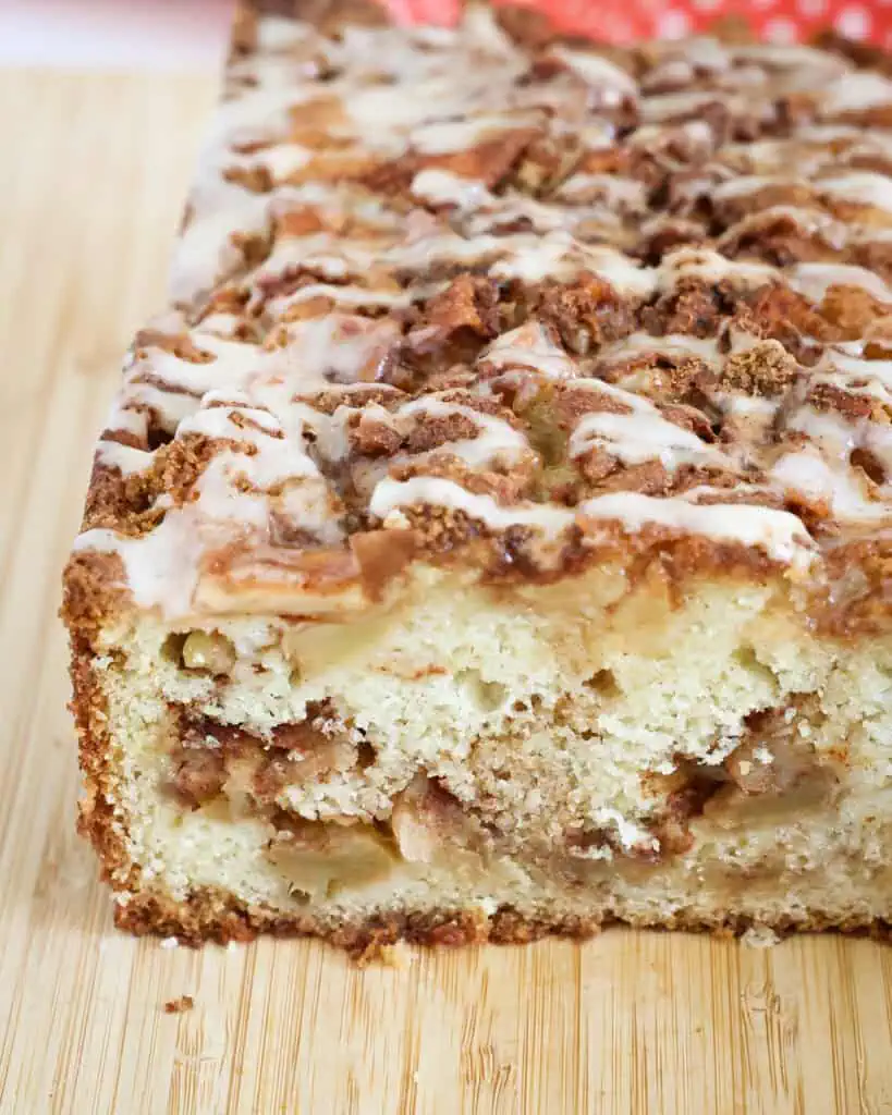 A close up view of cup apple fritter bread on a wooden cutting board. 