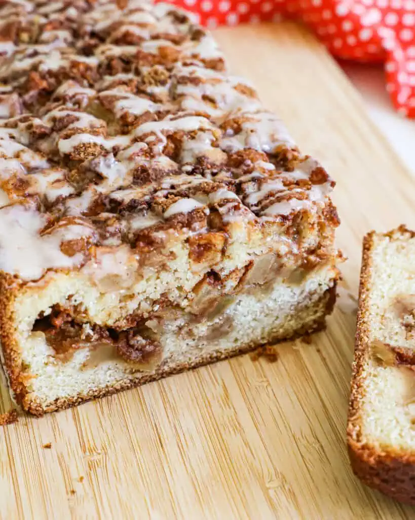 A cut loaf of apple fritter bread on a cutting board. 