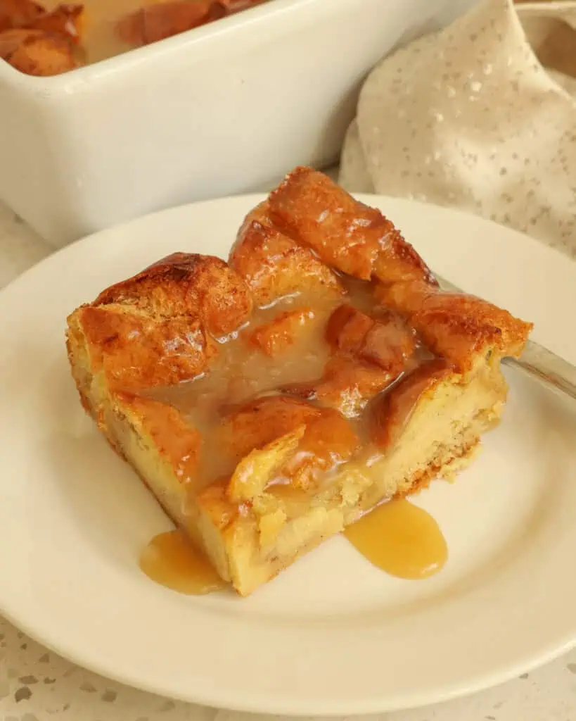 An individual slice of bread pudding with vamilla sauce. 