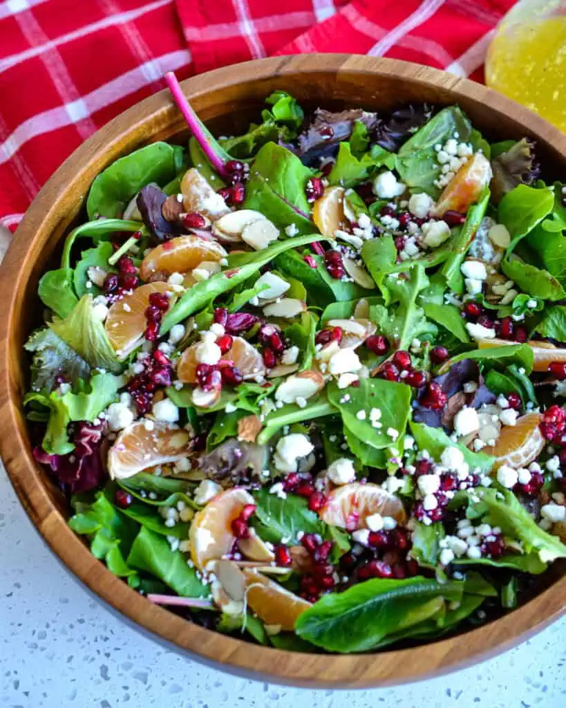 Overhead view of Christmas salad with almonds, mandarin oranges, feta cheese and pomegranite seeds. 