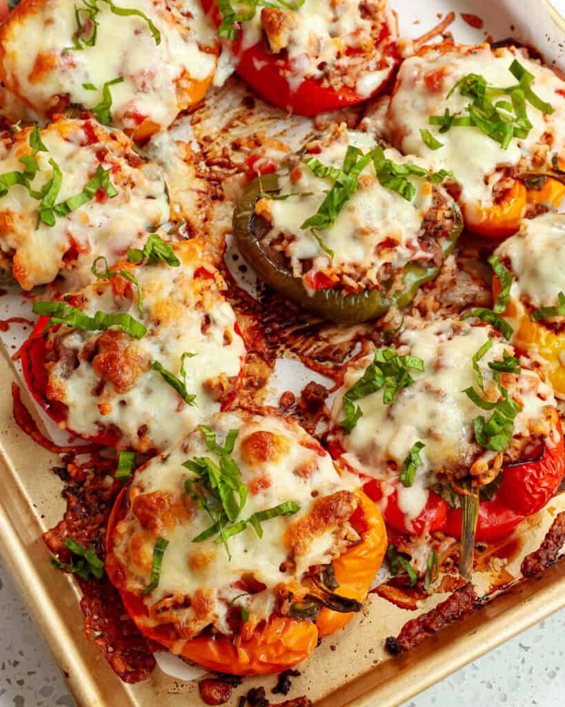 A sheet pan full of baked stuffed bell peppers. 