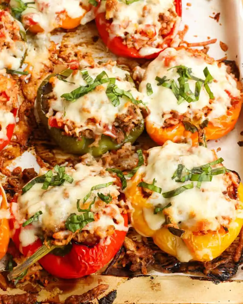 Baked Stuffed Peppers with ground beef, rice, and cheese on a baking sheet. 