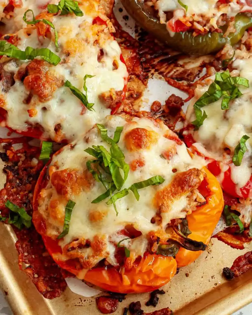 Baked bell peppers on a parchment covered baking sheet. 