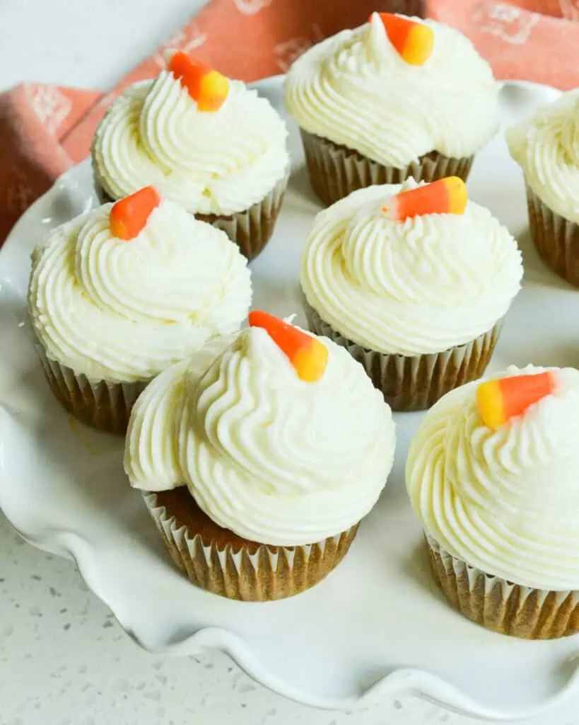 Pumpkin cupcakes garnished with candy corn on the top. 