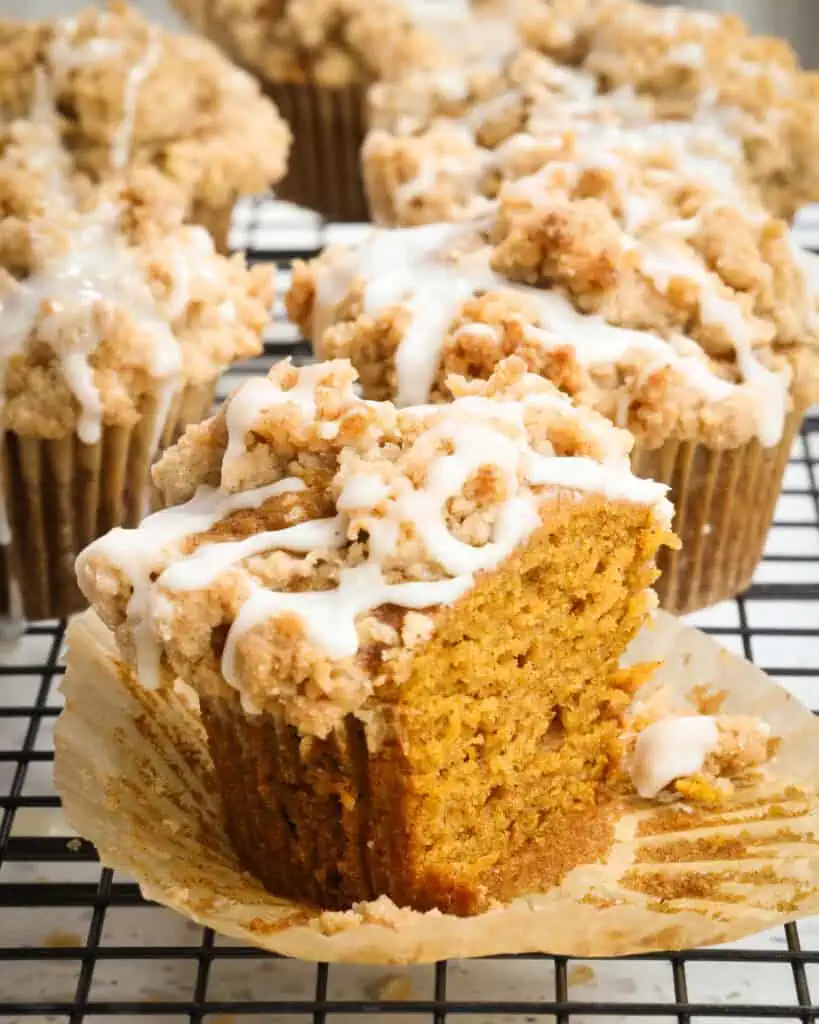 A pumpkin muffin cut in half on a paper liner. 