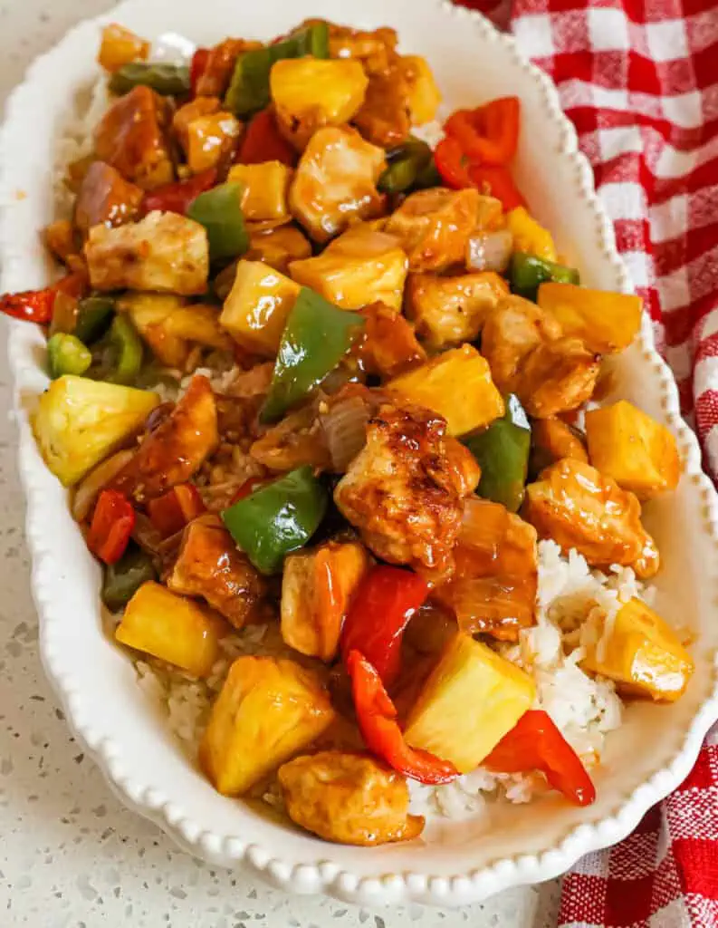 Sweet and sour chicken over rice on a platter. 