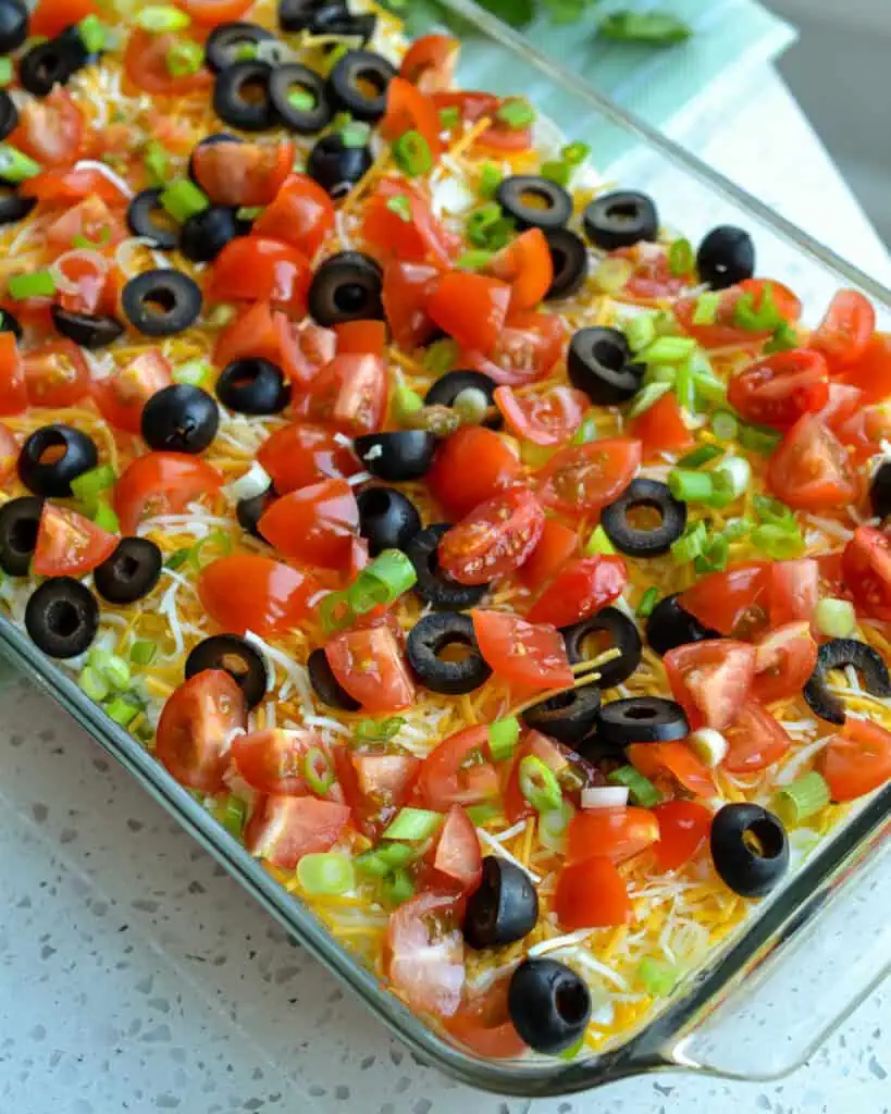 An over veiw of 7 layer dip in a glass dish
