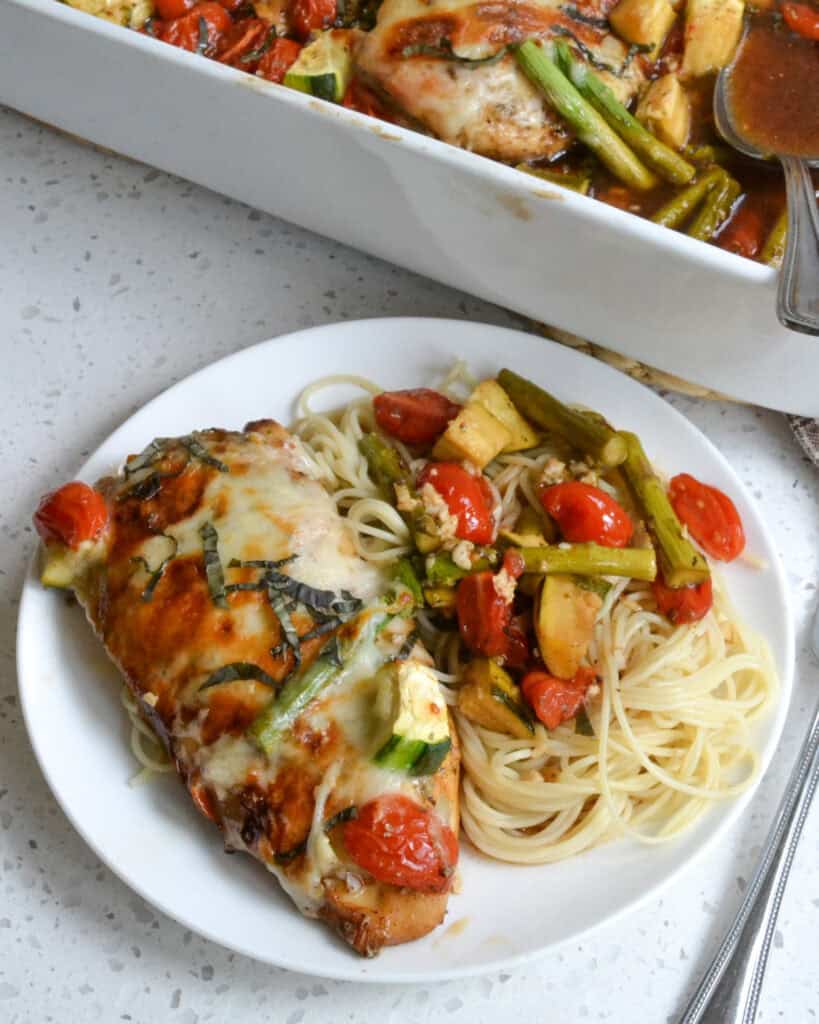 A plate full of angel hair pasta, balsamic chicken, and vegetables. 