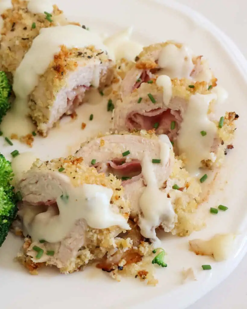 Sliced chicken cordon bleu topped a Parmesan cheese sauce and chopped fresh chives. 