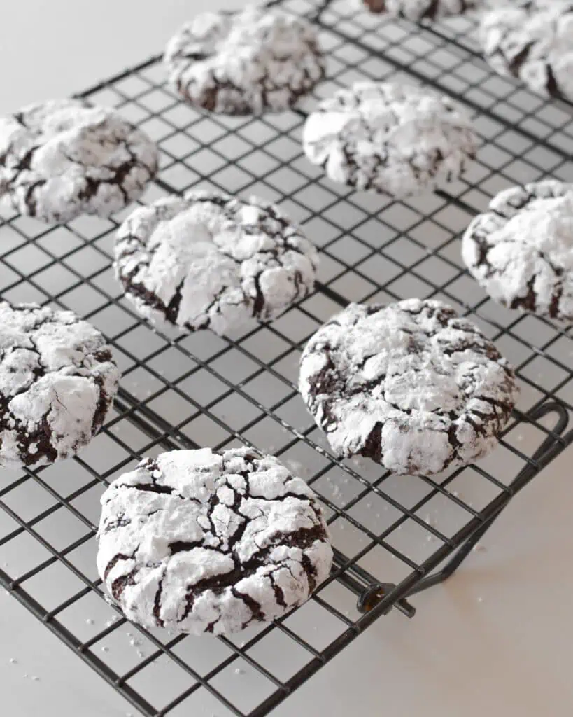 Chocolate crinkle cookies on a cooling rack. 