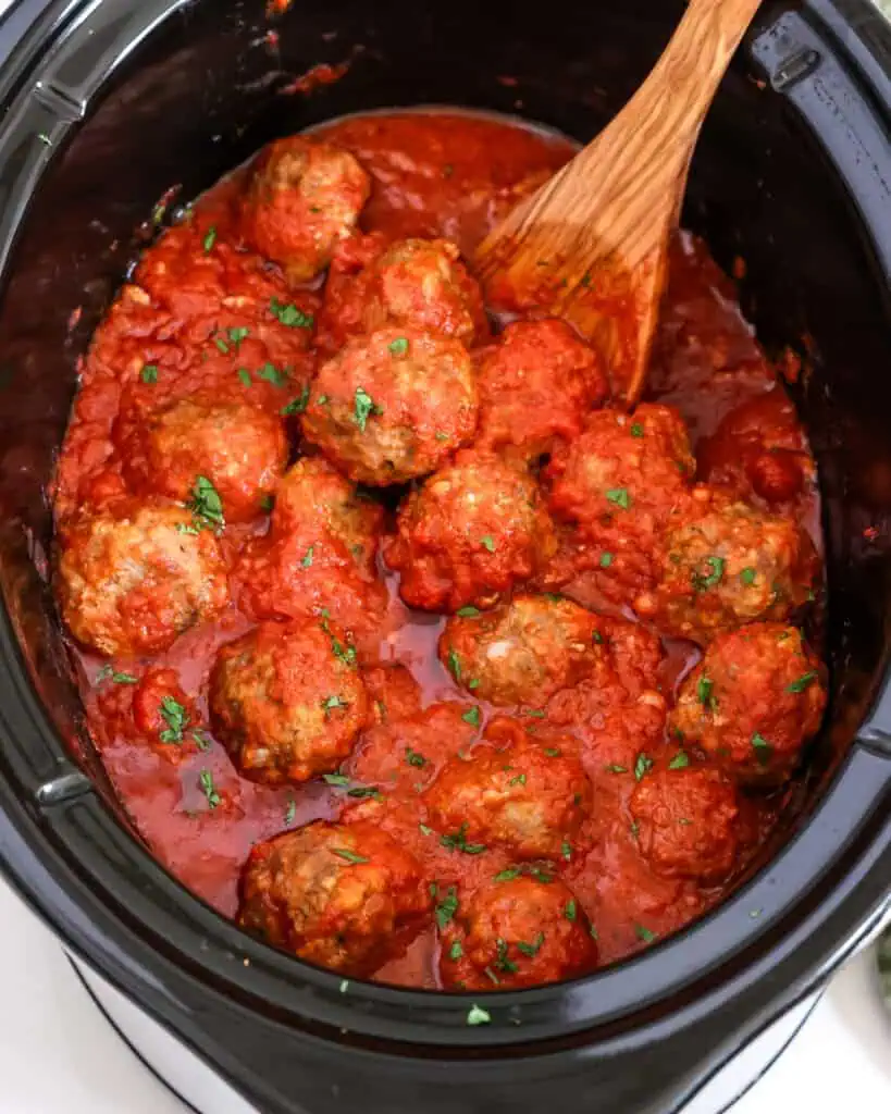 A slow cooker full of homemade meatballs with sauce. 