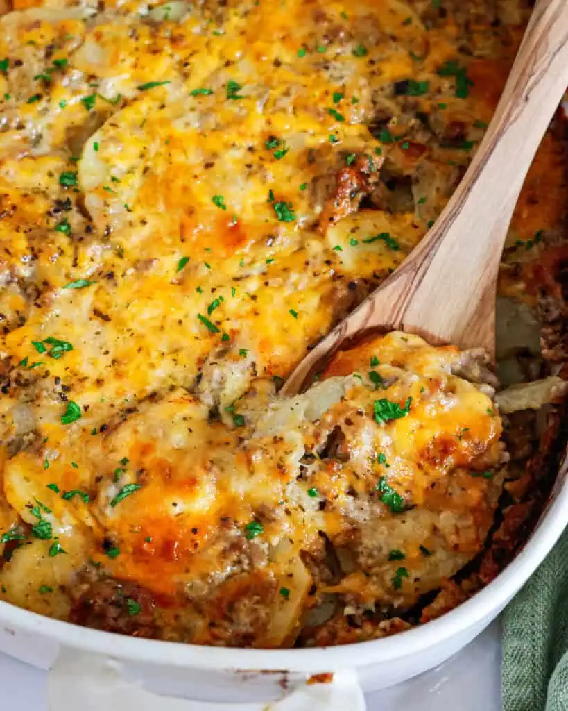 A casserole dish full of cheesy ground beef and potatoes. 