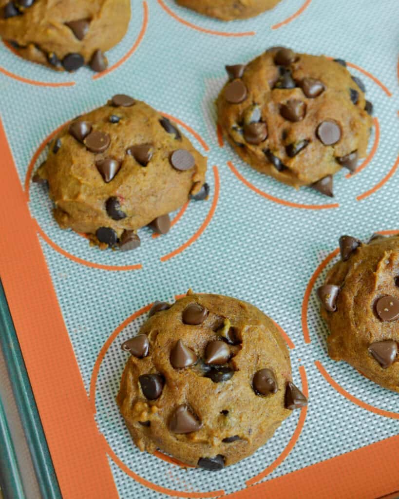 Fresh baked pumpkin cookies on a baking sheet. 