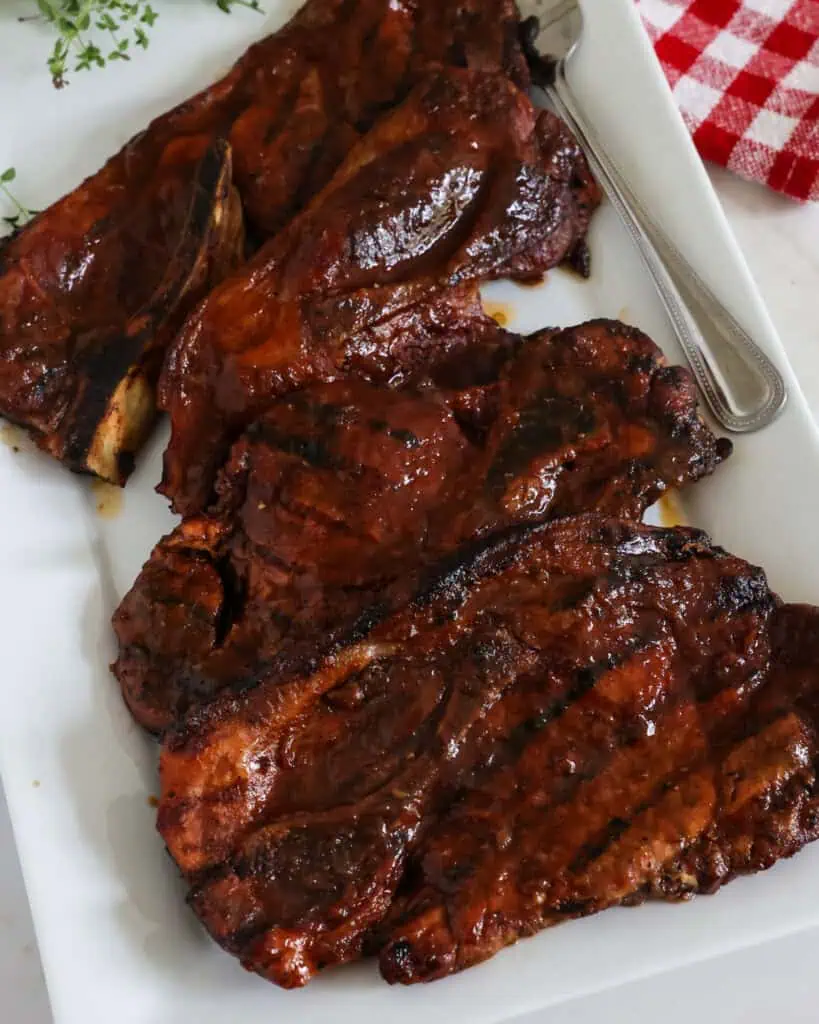 A close up view of pork steaks on a serving platter.