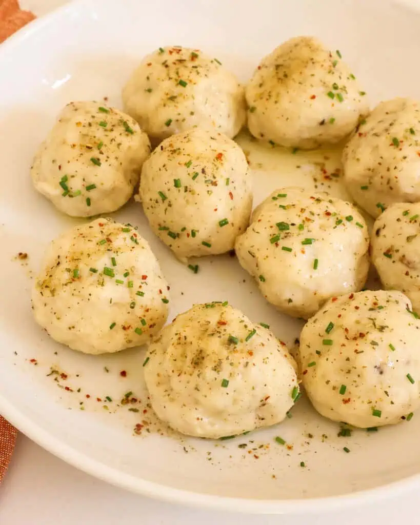 A serving bowl full of potato dumplings. 