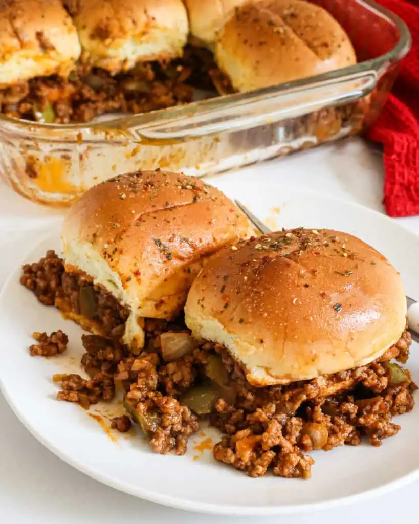 Sloppy joe casserole on a single serving plate with the sloppy joe casserole in the background. 