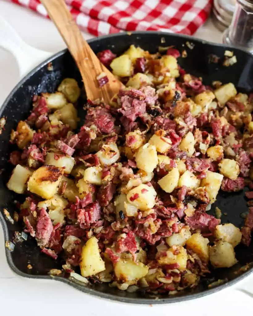 An overhead view of corned beef hash in a cast iron skillet. 