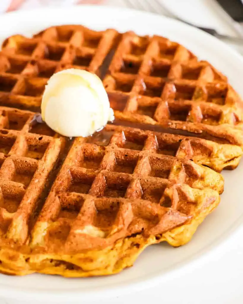 A pumpkin waffle with butter and pure maple syrup. 