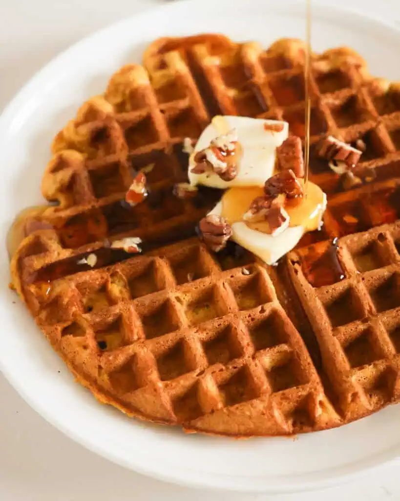 Pumpkin waffle with butter, pecans, and a drizzle of maple syrup. 