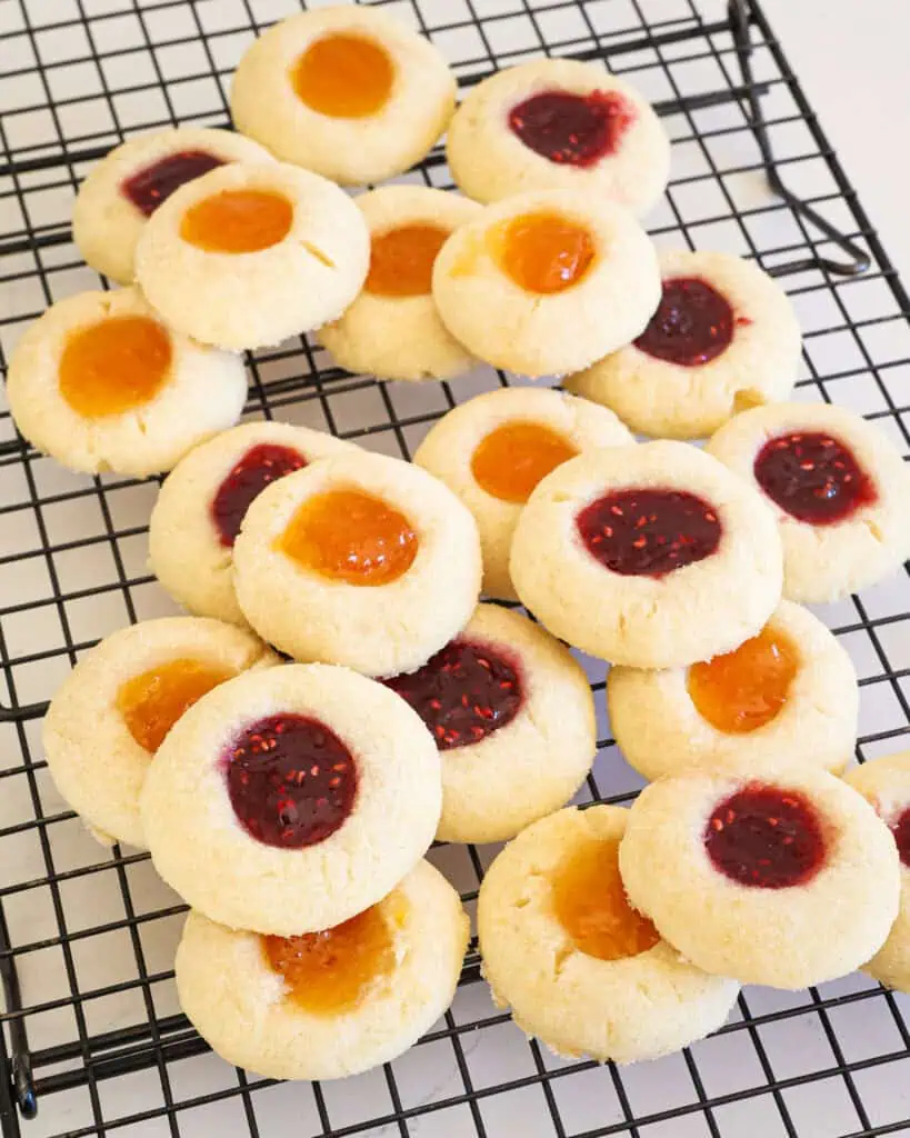 Raspberry and apricot thumbprint cookies on a cooling rack. 