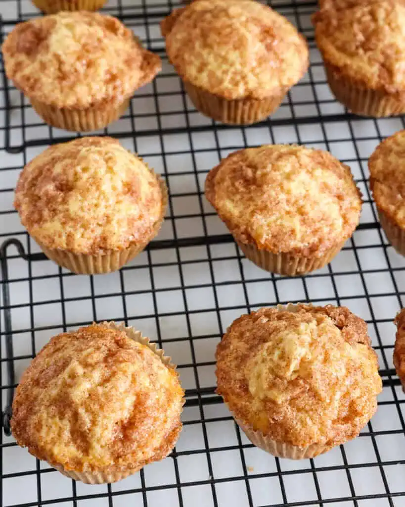 Overhead view of cinnamon muffins on a cooling rack. 