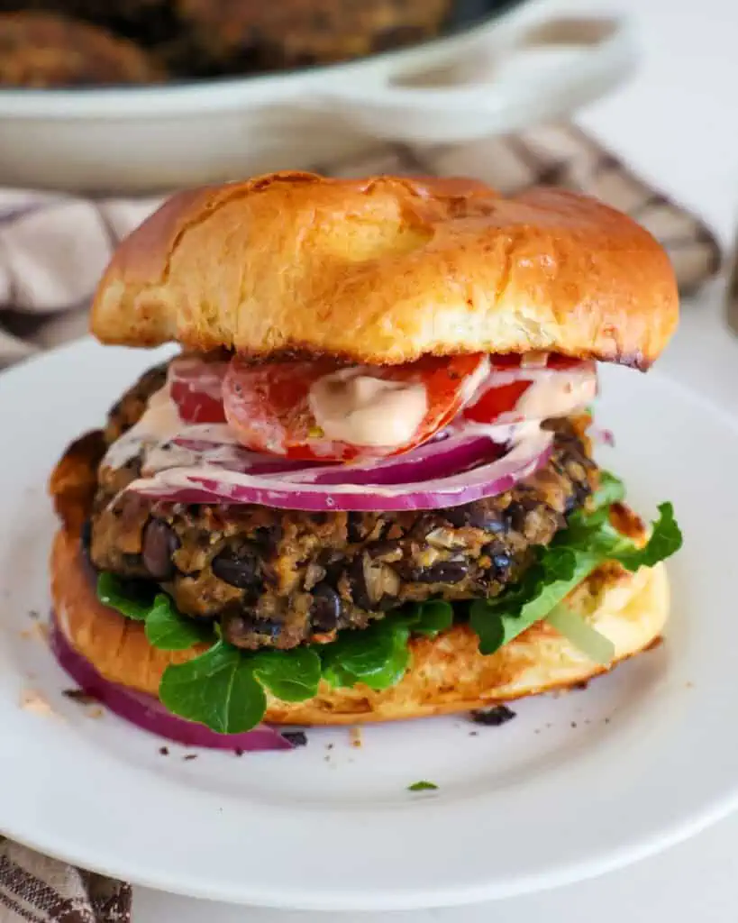 A black bean burger with lettuce and chipotle mayo on a toasted bun. 